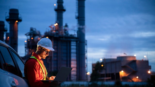 Petrochemical engineers work slowly and heavily with smart tablets in the oil and gas industry at night. 
