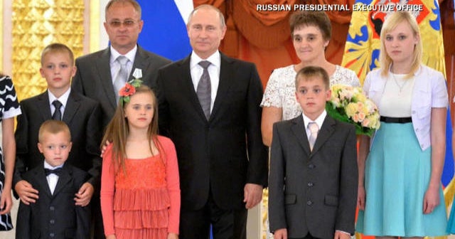 Vladimir Putin poses with happy families in awkward photos