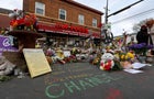 People lay flowers at a memorial in George Floyd Square 