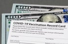 Covid-19 vaccination record card and cash money. Fake, vaccine card fraud and forgery concept 