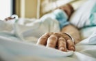 Senior woman wearing face mask lying on hospital bed 