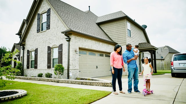 Portrait of family in driveway in front of home