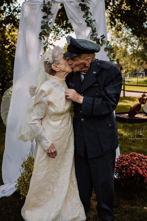 elderly bride and groom kiss at the altar