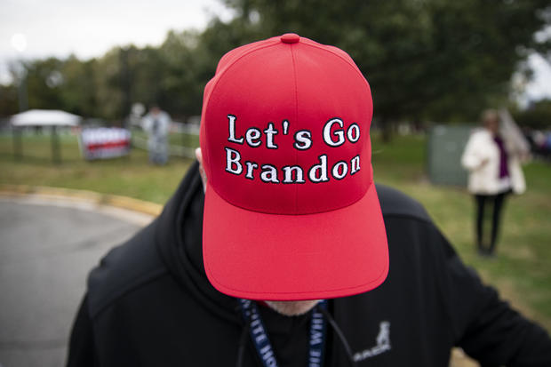 Man wears a "Let's Go Brandon" hat before a campaign event  in Virginia 