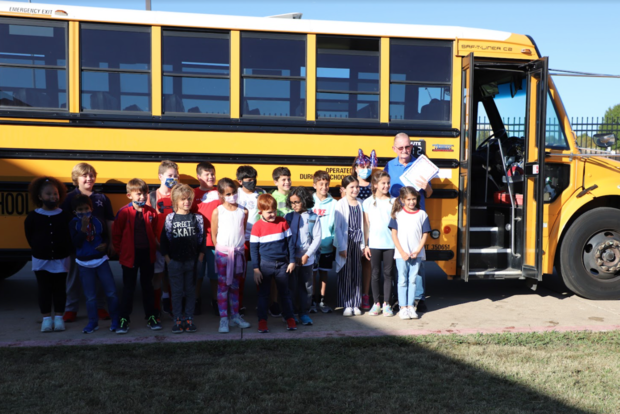 School bus driver and veteran Tommy Thompson with students 