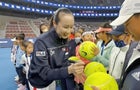 Chinese tennis player Peng Shuai signs large-sized tennis balls at the opening ceremony of Fila Kids Junior Tennis Challenger Final in Beijing 