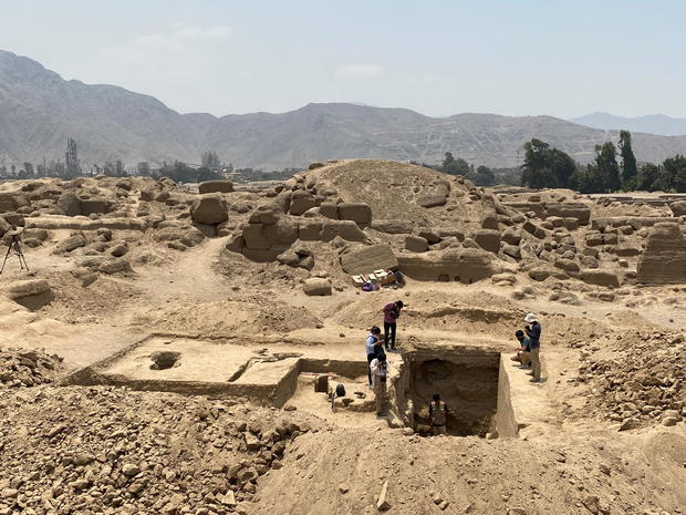 Peruvian archeologists work at an excavation site to recover the remains of 14 pre-Incan mummies, six children and eight adults which are nearly 1000 years old, at the archeological complex in Cajamarquilla 