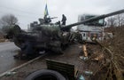 Ukrainian serviceman stands at a captured Russian tank in the north of the Kharkiv region 