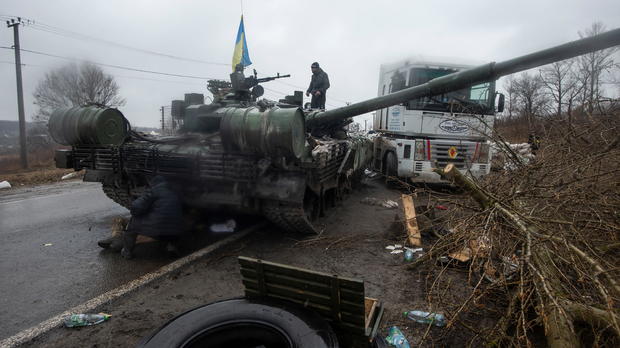 Ukrainian serviceman stands at a captured Russian tank in the north of the Kharkiv region 