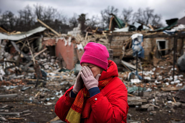 Irina Moprezova, 54, reacts in front of a house that was damaged in an aerial bombing in the city of Irpin, northwest of Kyiv, on March 13, 2022. 