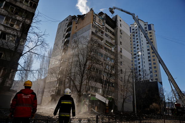 Rescuers work next to an apartment building that was hit by shelling in Kyiv 