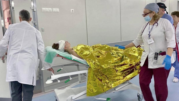 27-річна українка Ольга, важко поранена під час триваючого вторгнення Росії в Україну, укриваючи свою дитину від осколкових вибухів, лежить на ношах у Києві.