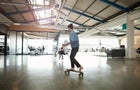 Woman cruising on longboard at creative office 