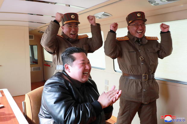 North Korean leader Kim Jong Un reacts next to military officials during what state media reports is the launch of the "Hwasong-17" intercontinental ballistic missile (ICBM) 