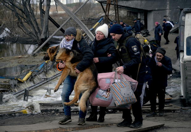 A man carries a dog as people flee amid Russia's invasion of Ukraine 