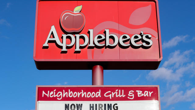A view of "now hiring" sign and logo at an Applebee's 