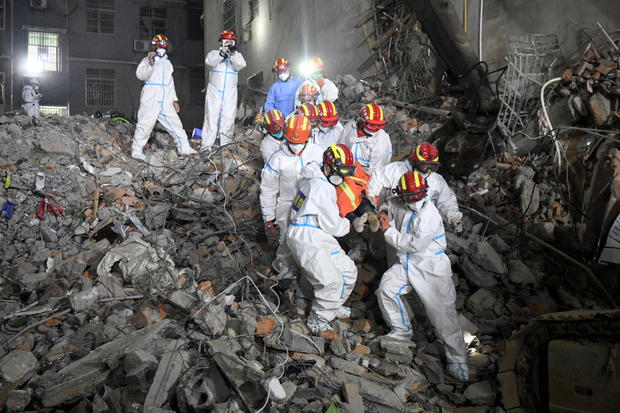 Kurtarma ekipleri, Changsha'da bir bina çöktükten sonra bir sedyede hayatta kalan birini taşıyor 
