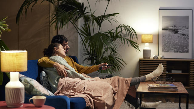 Mid Adult Couple Watching TV In Living Room 