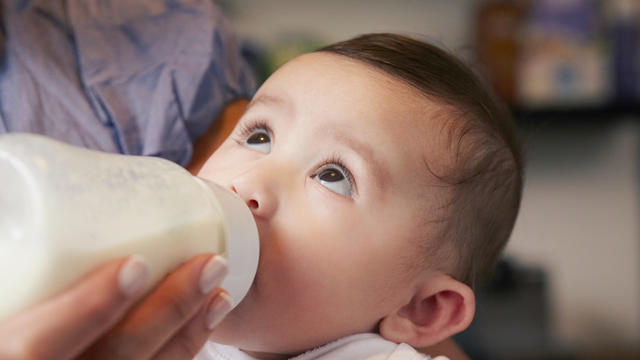 Baby girl drinking bottle of milk 