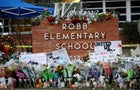 Flowers, candles and signs are left at a memorial for victims of the Robb Elementary School shooting, three days after a gunman killed nineteen children and two teachers, in Uvalde, Texas, May 27, 2022. 
